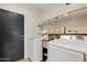 Well-organized laundry room featuring modern machines, shelving, and ample storage for convenience at 19339 E Mockingbird Dr, Queen Creek, AZ 85142