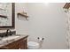 Stylish powder room features a granite countertop and a decorative mirror, complemented by floral wallpaper at 19339 E Mockingbird Dr, Queen Creek, AZ 85142