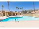 A spacious community pool with a hot tub, cabana, surrounded by palm trees with nearby buildings at 222 W Brown Rd # 72, Mesa, AZ 85201