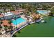 Stunning aerial view of the lakefront community pool with a sandy beach, clubhouse, and lake access at 2301 E Beachcomber Dr, Gilbert, AZ 85234