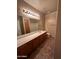Large bathroom with long vanity and dark floor tiles at 2301 E Beachcomber Dr, Gilbert, AZ 85234