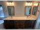 Bathroom features dual vanities with framed mirrors, updated lighting, and modern faucets at 2301 E Beachcomber Dr, Gilbert, AZ 85234