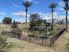 Enclosed community garden with raised beds, lush vegetation, and seating under shaded pergola at 2301 E Beachcomber Dr, Gilbert, AZ 85234