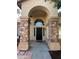 Covered front entrance with stone pillars and arched window above the front door at 2301 E Beachcomber Dr, Gilbert, AZ 85234