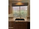 This kitchen sink features a granite countertop, wood cabinets, and a window for plenty of natural light at 2301 E Beachcomber Dr, Gilbert, AZ 85234