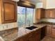 The kitchen features a granite countertop, wood cabinets, and a window for plenty of natural light at 2301 E Beachcomber Dr, Gilbert, AZ 85234