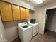 This laundry room features a modern washer and dryer set and plenty of cabinet space for storage at 2301 E Beachcomber Dr, Gilbert, AZ 85234