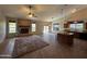 Open-concept living space with stone fireplace, kitchen island, and ceiling fan at 2301 E Beachcomber Dr, Gilbert, AZ 85234