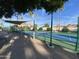 Community tennis court with shaded seating area, ideal for enjoying matches and practicing your swing at 2301 E Beachcomber Dr, Gilbert, AZ 85234