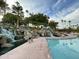 Scenic water feature with multiple waterfalls, a pool, and lush landscaping with palm trees in a community at 2301 E Beachcomber Dr, Gilbert, AZ 85234