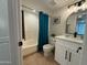 Bathroom featuring a shower over tub with blue curtain, white vanity, and a framed mirror with lighting above at 2331 W Via Rialto Cir, Mesa, AZ 85202