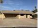 Home exterior featuring a covered parking area, large driveway, and desert landscaping at 2331 W Via Rialto Cir, Mesa, AZ 85202