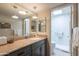 Well-lit bathroom featuring granite counters, a vessel sink, and a marble-lined walk-in shower with a skylight at 2413 E Rancho Dr, Phoenix, AZ 85016