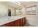 Bathroom with double sinks, large mirror, soaking tub, and glass door shower at 25060 W Vista Norte St, Buckeye, AZ 85326