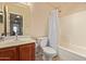 Bright bathroom featuring a sink with a wooden cabinet and a shower/tub combo at 25060 W Vista Norte St, Buckeye, AZ 85326