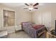 Cozy bedroom featuring a ceiling fan, window with blinds, and comfortable bed at 25060 W Vista Norte St, Buckeye, AZ 85326