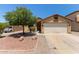 Charming single-story home with low maintenance desert landscaping, two car garage, and mature shade tree at 25060 W Vista Norte St, Buckeye, AZ 85326