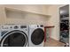Modern laundry room with front loading washer and dryer and wooden countertop at 25060 W Vista Norte St, Buckeye, AZ 85326