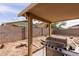 Covered patio and barbecue grill in a spacious backyard with block wall fencing at 2509 E Meadow Land Dr, San Tan Valley, AZ 85140