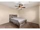 Cozy bedroom with a ceiling fan and a rustic wood-frame bed on carpet at 2509 E Meadow Land Dr, San Tan Valley, AZ 85140