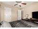 This bedroom boasts a bed, dark furnishings, and a ceiling fan overhead at 2509 E Meadow Land Dr, San Tan Valley, AZ 85140