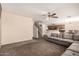 Spacious living room featuring plush carpeting, ceiling fan, and seamless access to kitchen at 2509 E Meadow Land Dr, San Tan Valley, AZ 85140