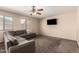 A living room with a carpet flooring, a ceiling fan, and a large sofa at 2509 E Meadow Land Dr, San Tan Valley, AZ 85140