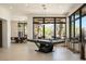 Bright game room boasting a pool table, bar-style seating, and large windows with views of the outdoor landscape at 26285 N 89Th St, Scottsdale, AZ 85255