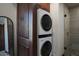 Modern laundry with stacked front load washer and dryer are situated next to built-in cabinets at 26285 N 89Th St, Scottsdale, AZ 85255