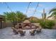 Charming outdoor fireplace and pizza oven, set on a stone patio with comfortable seating, ideal for relaxing evenings at 26285 N 89Th St, Scottsdale, AZ 85255