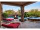 Stunning outdoor pool area with waterfall feature, fire pit, and luxurious lounge chairs at 26285 N 89Th St, Scottsdale, AZ 85255