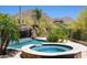 Relaxing outdoor space featuring a pool with a waterfall and a connected hot tub with desert views at 26285 N 89Th St, Scottsdale, AZ 85255