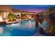 Backyard featuring a pool with rock waterfall, a covered patio, fire features, and mature landscaping at 26285 N 89Th St, Scottsdale, AZ 85255