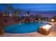 Resort style pool with grotto, rock waterfall, slide and fire feature, all set against a desert sunset at 26285 N 89Th St, Scottsdale, AZ 85255