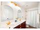 Bathroom with a double sink vanity, modern lighting, and gold fixtures with a shower in the background at 2990 E Franklin Ave, Gilbert, AZ 85295