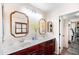 This bright bathroom features a double vanity, framed mirrors, and a walk-in closet at 2990 E Franklin Ave, Gilbert, AZ 85295