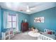 Cozy blue bedroom features a ceiling fan, white accents, and a dollhouse at 2990 E Franklin Ave, Gilbert, AZ 85295