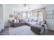 Bright living room area with neutral colors, a large sectional couch, and large windows at 2990 E Franklin Ave, Gilbert, AZ 85295