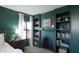 The home's main bedroom showcasing its built-in dark green bookshelves, matching the accent wall at 2990 E Franklin Ave, Gilbert, AZ 85295