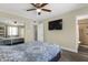 Bright bedroom with a ceiling fan, mirror closet doors and ensuite bathroom at 3116 W Calavar Rd, Phoenix, AZ 85053