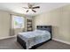 Bedroom featuring a ceiling fan, a window with natural light, and a comfortable bed at 3116 W Calavar Rd, Phoenix, AZ 85053
