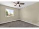 This bedroom features a ceiling fan and a window offering views of the home's exterior at 3116 W Calavar Rd, Phoenix, AZ 85053