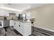 Modern kitchen with white cabinets, stainless steel appliances, gray countertops and breakfast bar at 3116 W Calavar Rd, Phoenix, AZ 85053