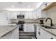 Modern kitchen with granite countertops, stainless steel appliances, and white cabinets at 3116 W Calavar Rd, Phoenix, AZ 85053