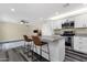 Modern kitchen with breakfast bar seating, stainless appliances, and living room area at 3116 W Calavar Rd, Phoenix, AZ 85053