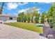 Backyard features turf, mature landscaping, and a spacious brick patio area at 3505 N Miller Rd, Scottsdale, AZ 85251