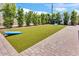 Backyard featuring artificial turf, brick trim, and cornhole boards on a sunny day at 3505 N Miller Rd, Scottsdale, AZ 85251