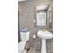 Bathroom featuring modern gray tiling, a pedestal sink, and a decorative mirror at 3505 N Miller Rd, Scottsdale, AZ 85251