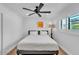 Bright bedroom featuring a queen bed, ceiling fan, and window with plantation shutters at 3505 N Miller Rd, Scottsdale, AZ 85251