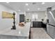 Modern kitchen features a large island with a marble countertop, black cabinetry, and stainless steel appliances at 3505 N Miller Rd, Scottsdale, AZ 85251